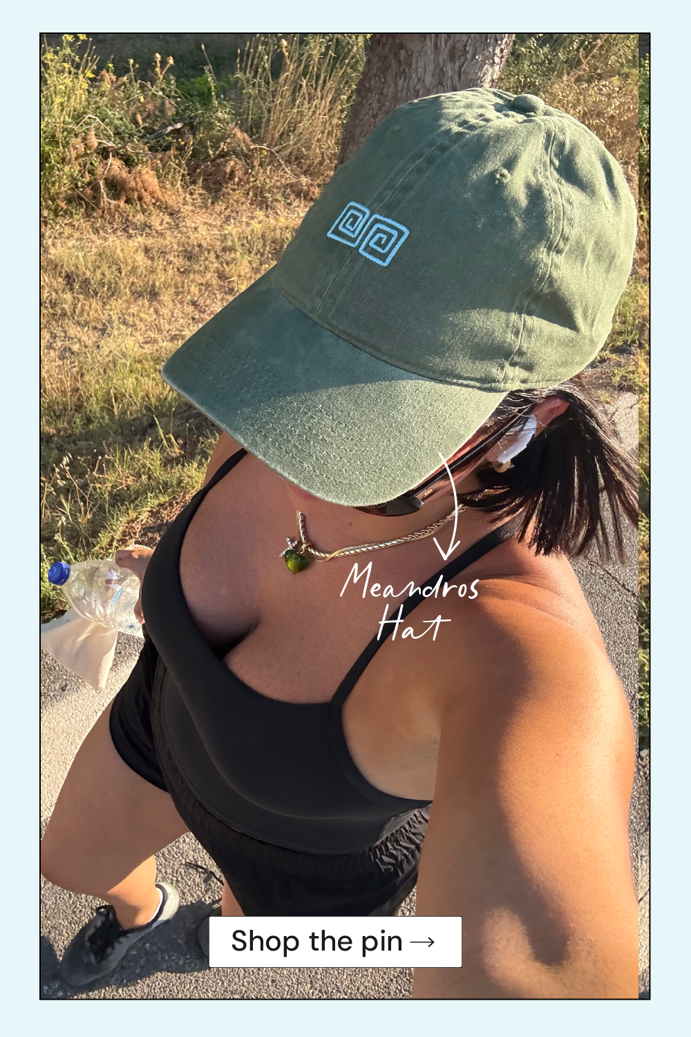 Person wearing a green cap with a logo, standing outdoors.