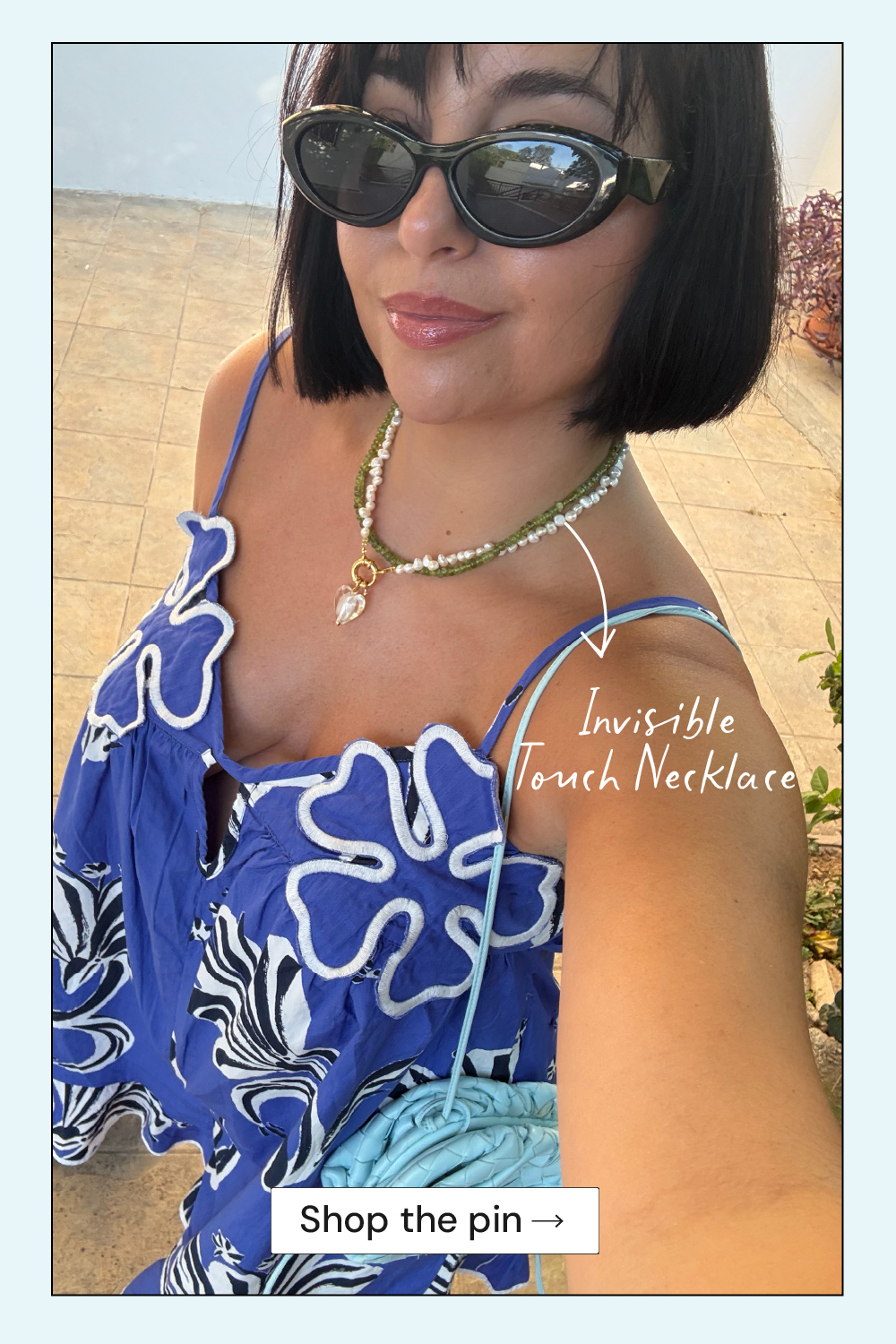 Woman wearing a blue floral dress and sunglasses with text overlay on a blurred outdoor background